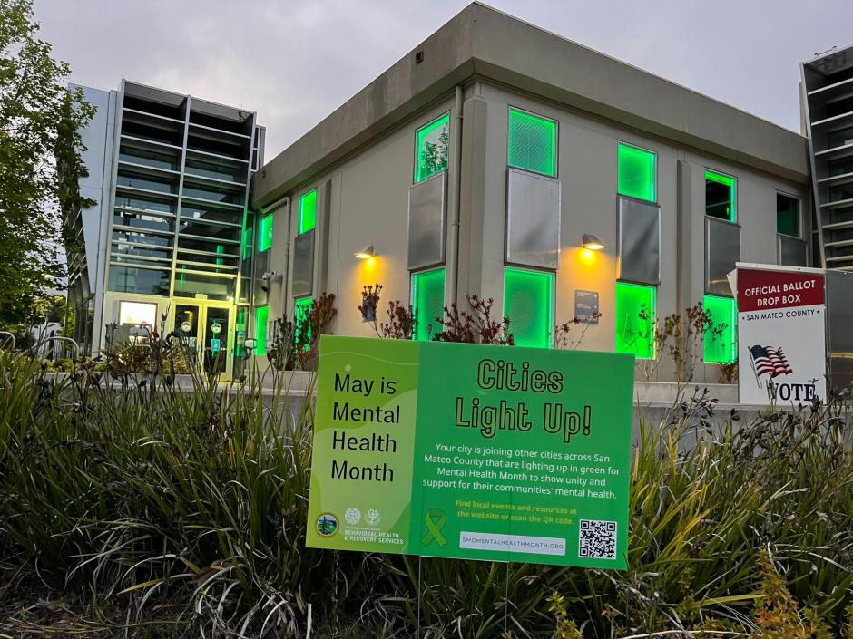 Brisbane City Hall building lit up in lime green and with lawn sign.